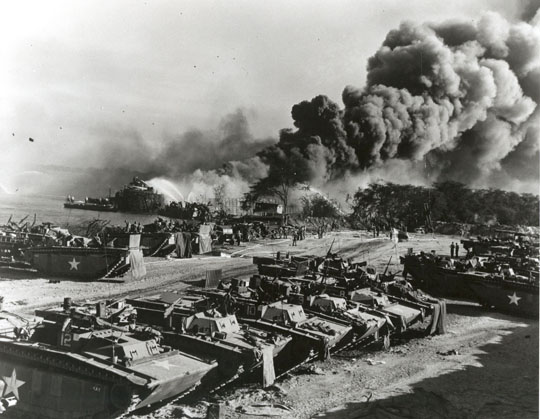 LVT's were brought ashore after the explosions at West Loch; an LST is on fire in the background, May 21st, 1944.