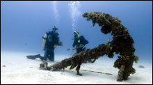 Divers survey for artifacts around a historic anchor at Welles Harbor in Midway Atoll  (Credit: Tane Casserley/NOAA)