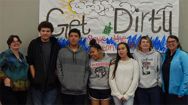students in front of a sign that says get dirty