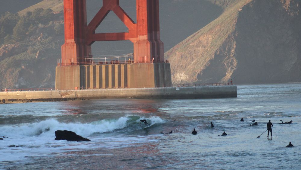Surfers at Fort Point under the Golden Gate Bridge