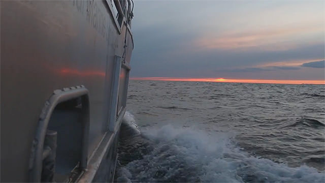 view of a sunset from the side of a ship