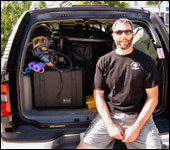 Russ takes a rest after loading the gear into the black Chevy Suburban.