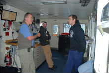 Daily safety meeting on the bridge of the NOAA Ship McArthur II with (left to right) Chief Scientist Ed Bowlby, Chief Bosun Brad Delinski, Operations Officer John Petersen, and Commanding Officer Greg Hubner.  Photo courtesy of NOAA Olympic Coast National Marine Sanctuary.
