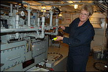 Linda Halderman checks equipment in the engine room to be sure it's working properly.