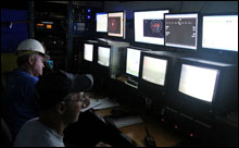 Inside the ROV control van, Dennis Arbige pilots and Jeff Hyland assists with navigation  