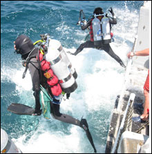 Scuba divers are deployed off of the stern of the Small Reserach Vessel, RV-8501.