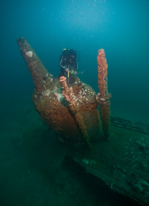 diver examines a wreck