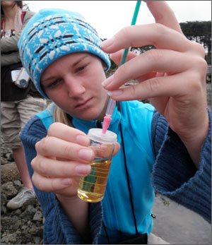 A student conducts water quality monitoring.
