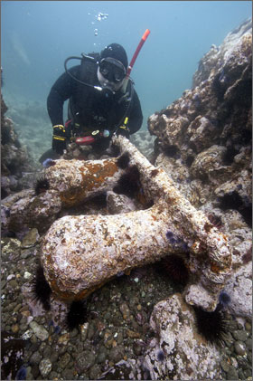 CMAR diver Patrick Smith examines one of two massive mooring bitts discovered at the George E. Billings site. Mooring lines were secured from the mooring bitts to similar bitts on wharfs and docks called bollards
