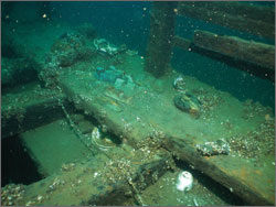Figure 34. Moved by divers from their original disposition on the wreck of the steamer Pewabic, several artifacts such as copper ingots and ceramic cups and plates have been placed on deck and are more likely to be looted. Although sanctuary regulations and Michigan law prohibit moving artifacts, the practice occurs at many sites where divers want to provide better viewing and photography opportunities. The sanctuary works with the dive community to curb this practice (see Response section). Clearly unacceptable is the handling and relocation of human remains, an activity that has been documented at the Pewabic site.