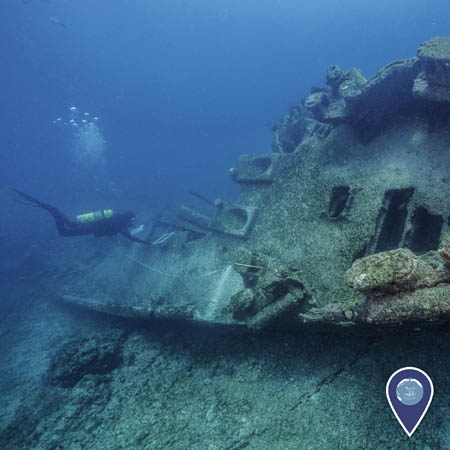 diver examines a shipwreck