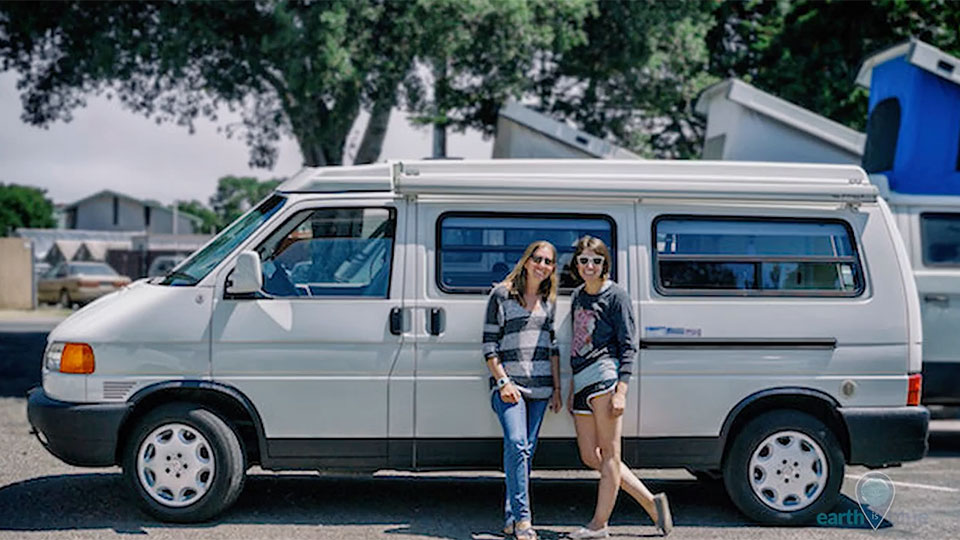 2 women standing in front of a white van
