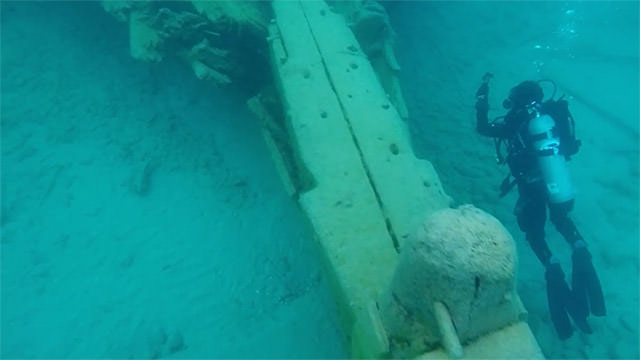 diver swimming by a shipwreck