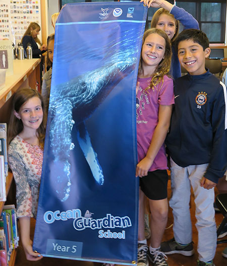 photo of kids holding up an ocean guardian sign