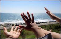 hands reaching towards the sea