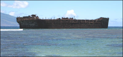The stout navy fuel barge YOGN-42, hard aground on the reef and broadside to the weather, as she has been for decades.   H Van Tilburg/NOAA ONMS