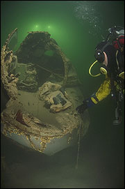 Diver inspects the B-29's crushed cockpit