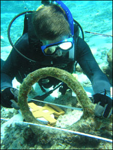 NOAA archaeologist measuring rigging elements near the reference baseline.