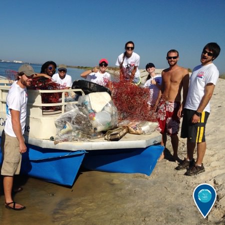 group of people posing with marine debris they have collected