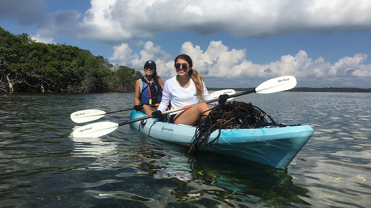 a pair of kayakers with marine debris they collected on their kayak