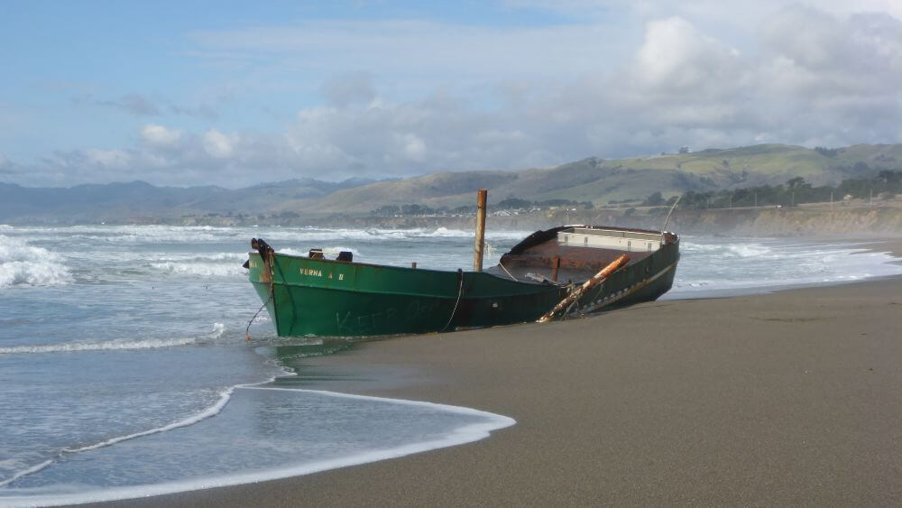 Abandoned vessel on the beach shore.