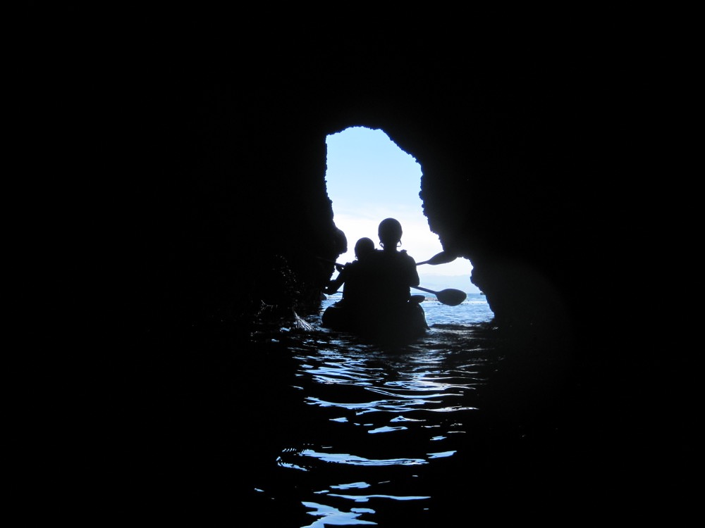 kayakers entering a sea cave