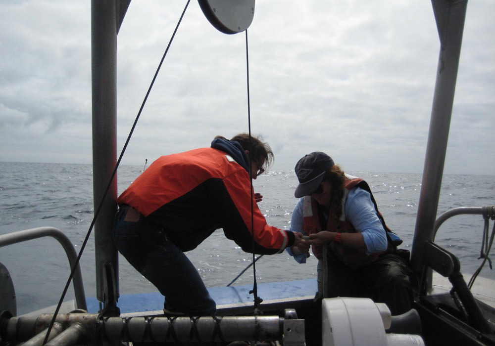 Danielle Lipski and Kate Hewett attach instruments to a mooring line as it is deployed
