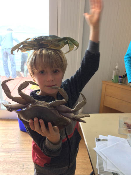 a child holds two large crabs