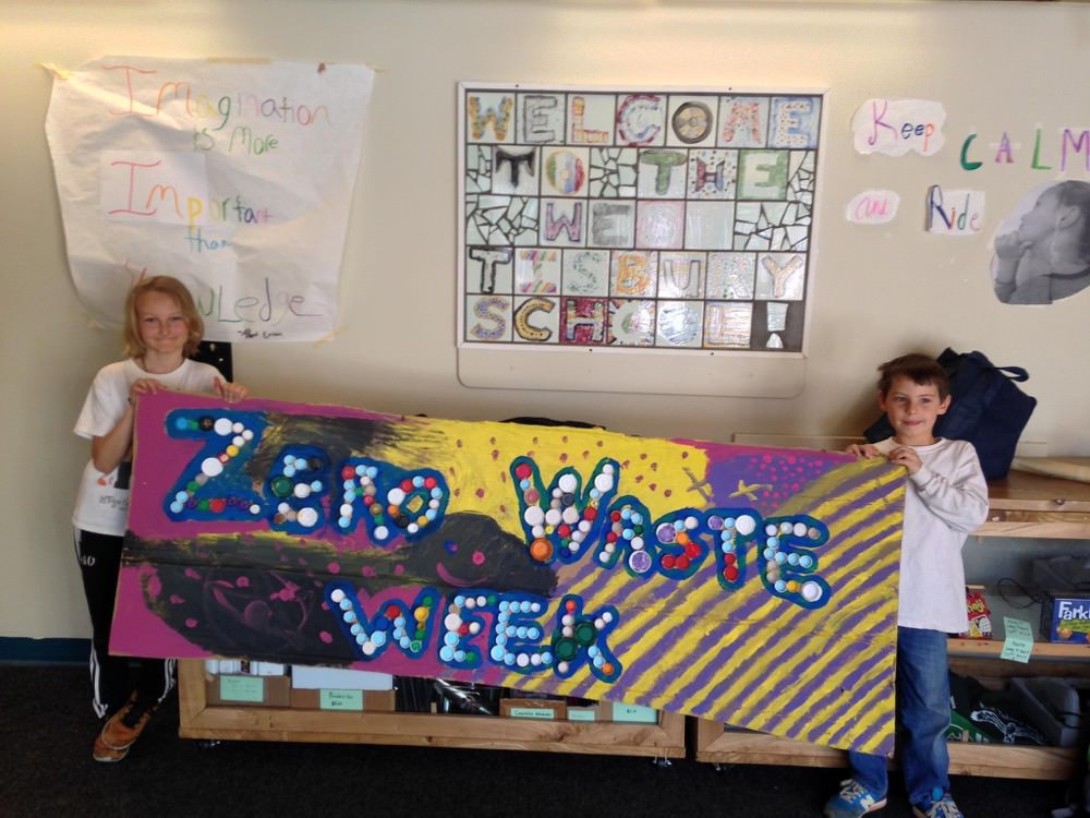 two students hold a zero waste week sign