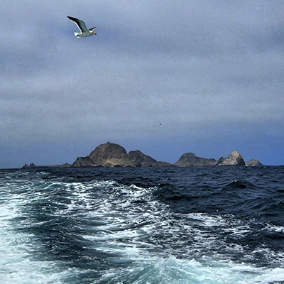 ocean in foreground with farallon islands in the distance