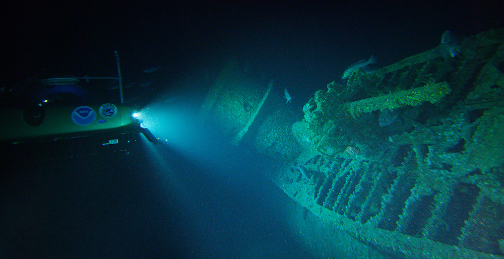 a submersible shines a light on a sunken uboat