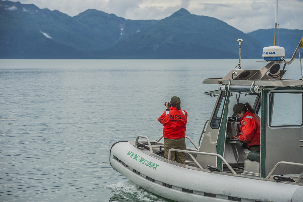 two national park service researchers on a boat in alaska