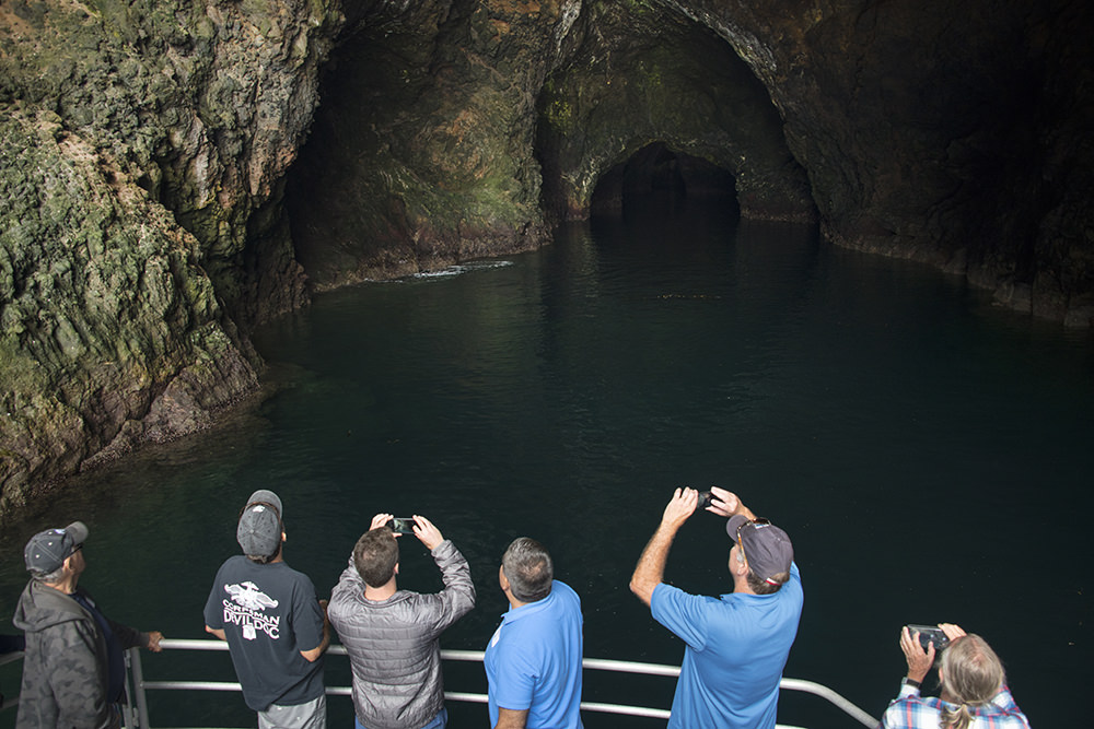 people photographing a sea cave