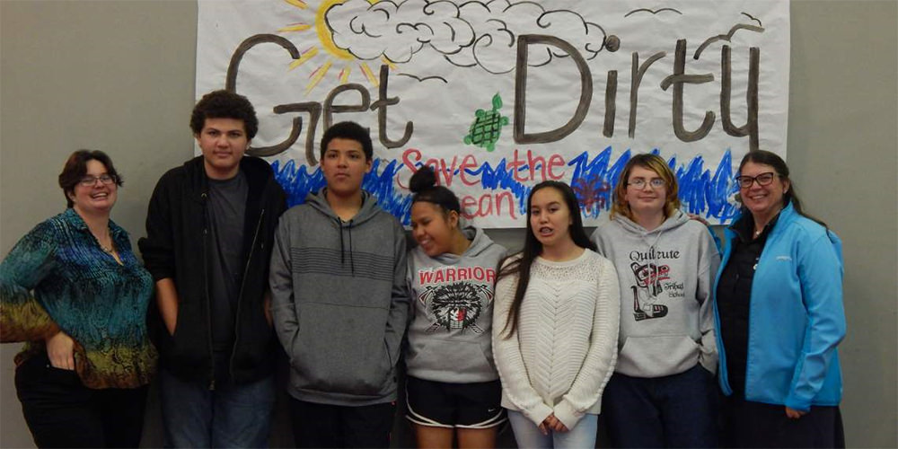 students in front of a sign that says get dirty