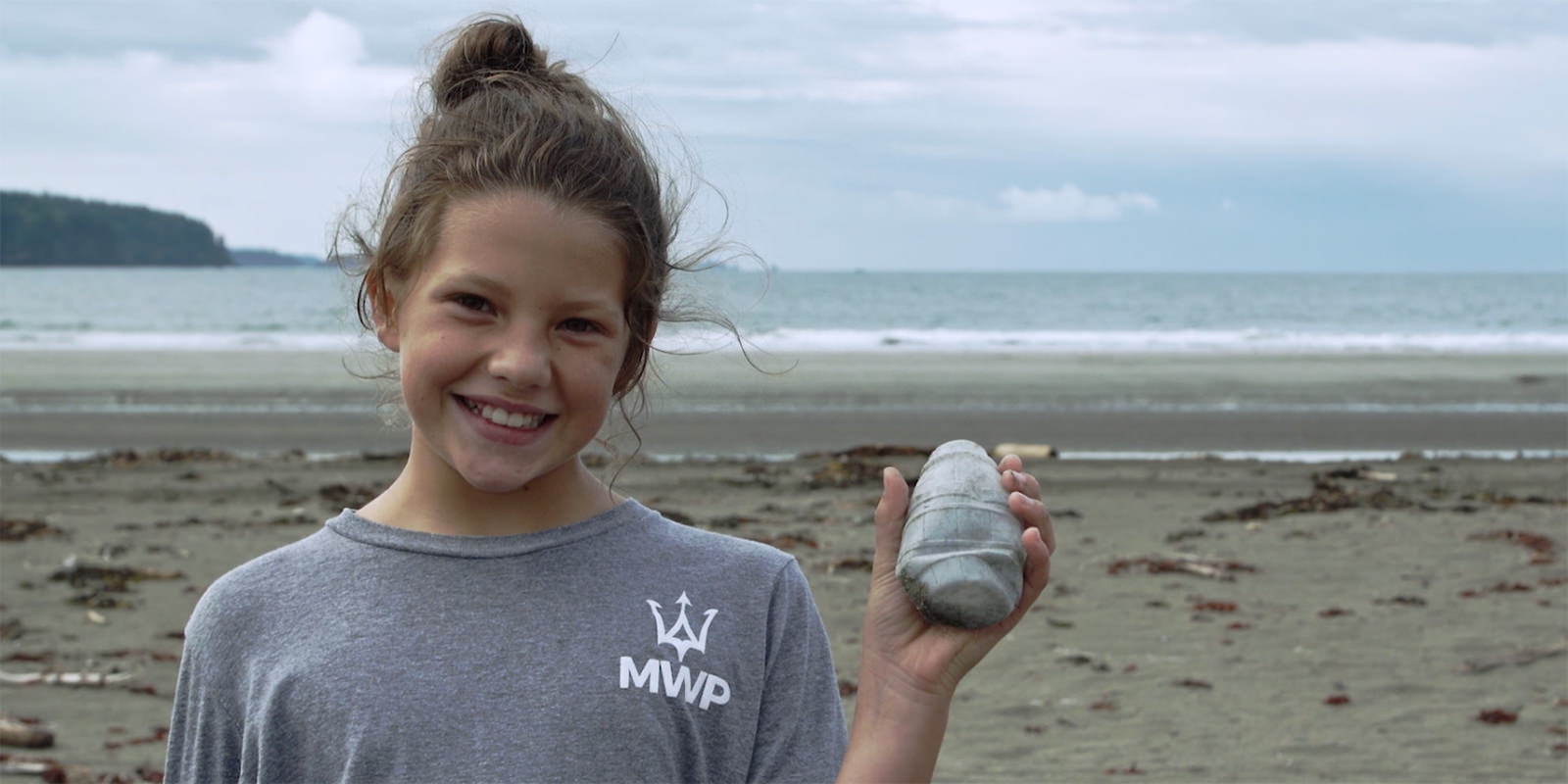 girl holding up marine debris