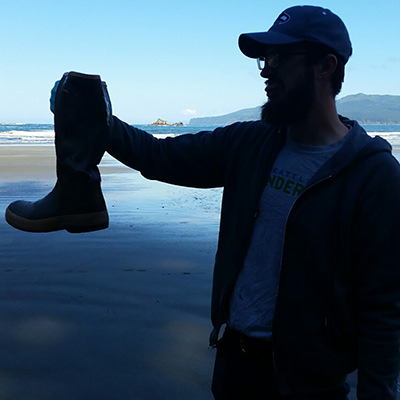 a person holding marine debris on a beach
