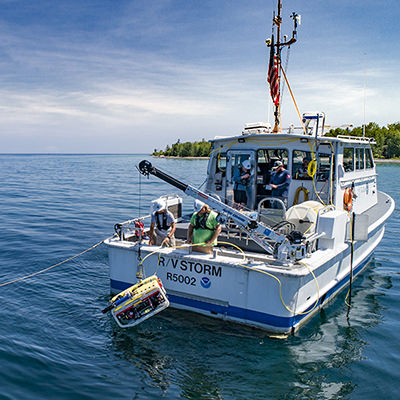 people prepping an ROV from a research vessel