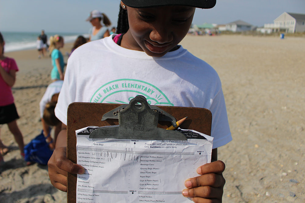 a student holding a data collection worksheet