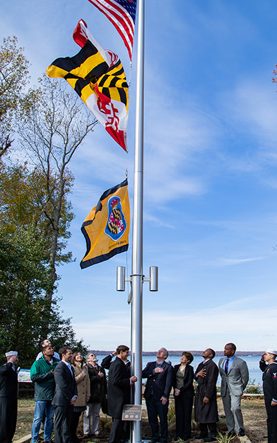 people raising the u.s., maryland, and charles county flags