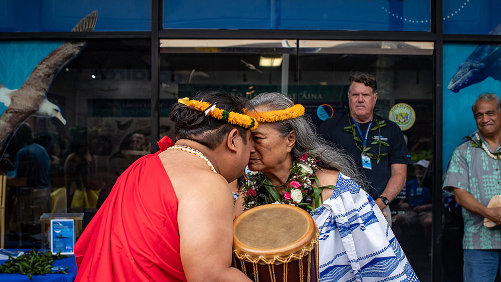 two people touching noses in the traditional hawaiian greeting