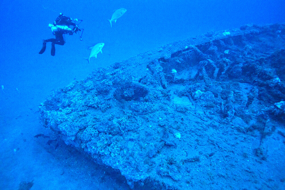 A diver inspects the wreck of the monitor