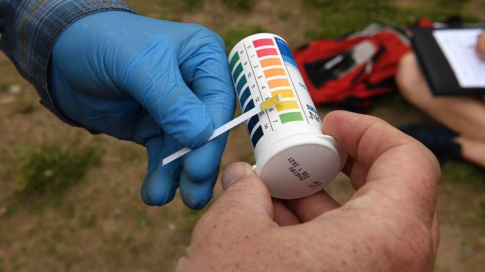 a volunteer holding a water ph test kit
