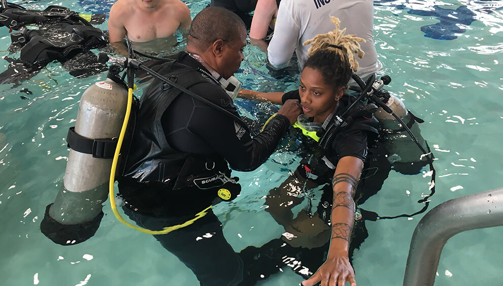 Scuba instructors teaching students in a pool