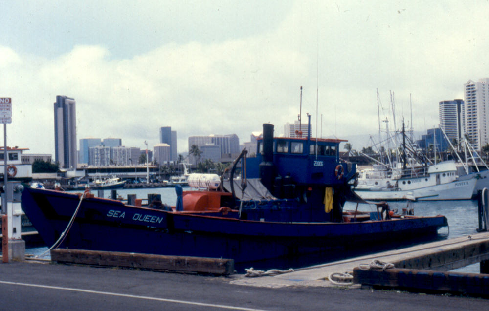 a blue ship with the name sea queen in harbor