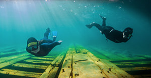 snorkelers swimming over a shipwreck
