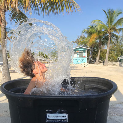 Kid flipping hair in large bin of water