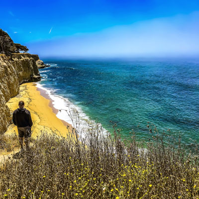 Person on a cliff overlooking ocean