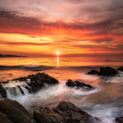 Water over rocks on ocean sunset