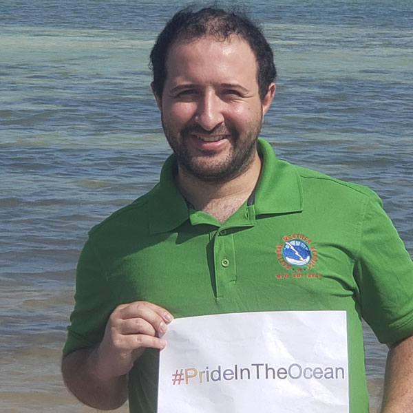 Person smiling holding a #PrideInTheOcean sign