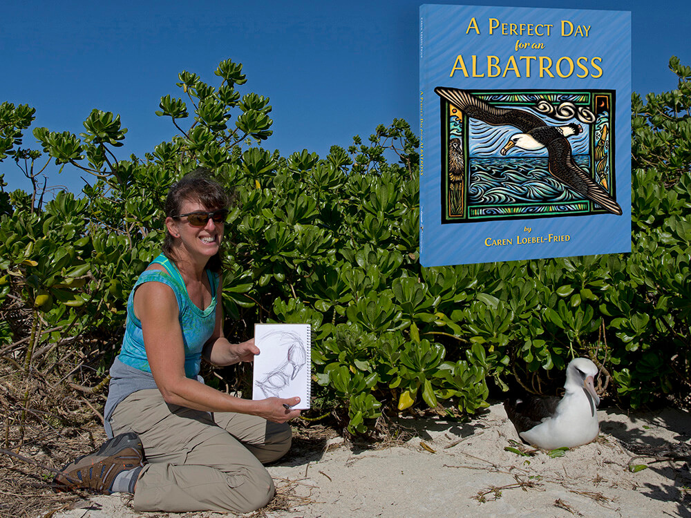 Photo of author and artist Caren Loebel-Fried crouching next to a Laysan albatross while showing a sketch of the same bird.